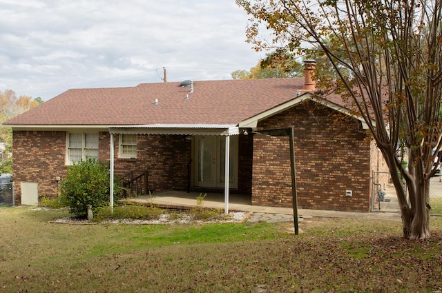 rear view of house with a yard and a patio