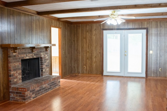 unfurnished living room featuring hardwood / wood-style flooring, plenty of natural light, and wooden walls