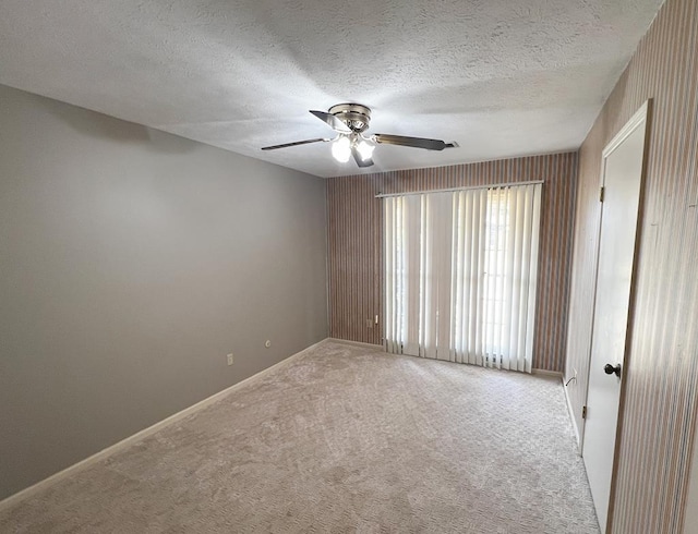 carpeted empty room featuring a textured ceiling and ceiling fan