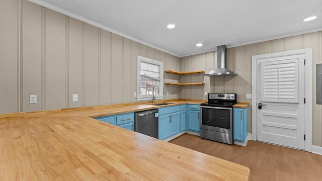 203 Patton Dr, Americus, GA 31719 - kitchen with wooden counters, blue cabinets, sink, wall chimney exhaust hood, and appliances with stainless steel finishes