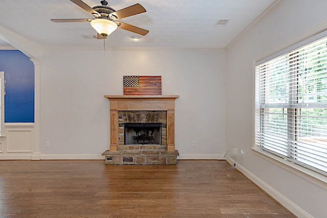 7177 Helen Dr, Columbus, GA 31904 - unfurnished living room featuring wood finished floors, a stone fireplace, arched walkways, ornamental molding, and ceiling fan