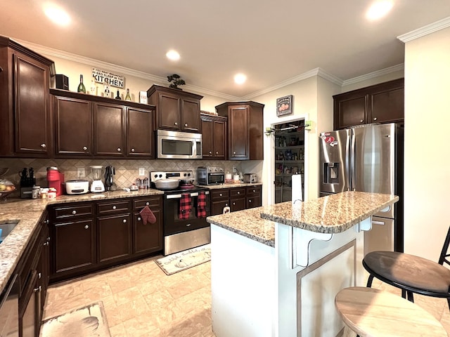 19 Pebblebrook Ln, Fort Mitchell, AL 36856 - kitchen featuring stainless steel appliances, a breakfast bar, light stone counters, dark brown cabinets, and a center island