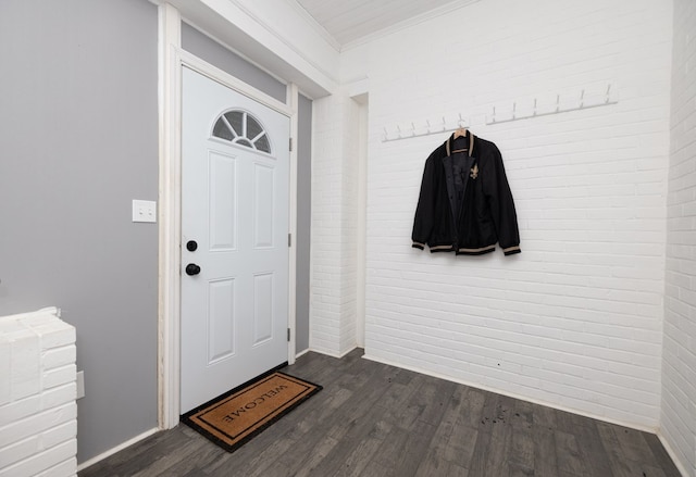 mudroom featuring dark hardwood / wood-style flooring, ornamental molding, and brick wall