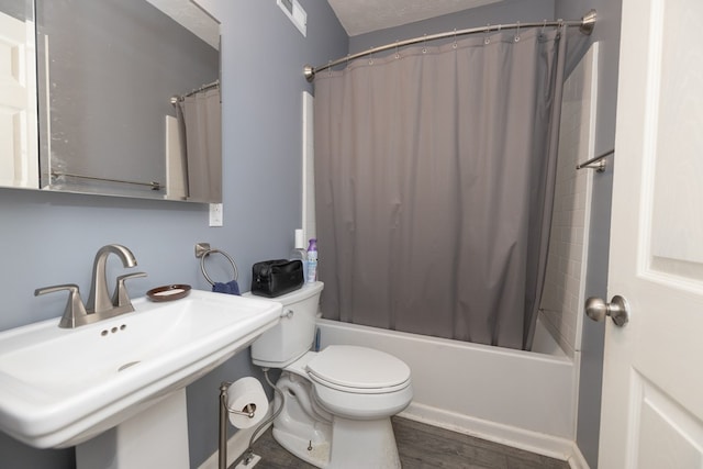 full bathroom with hardwood / wood-style flooring, toilet, shower / bathtub combination with curtain, and sink