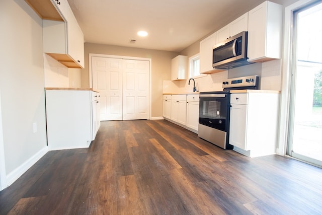 kitchen with a healthy amount of sunlight, stainless steel appliances, and white cabinets