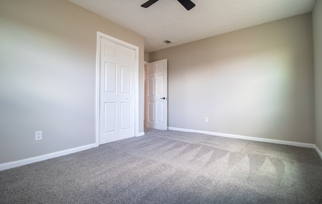 unfurnished bedroom featuring carpet, ceiling fan, and a closet