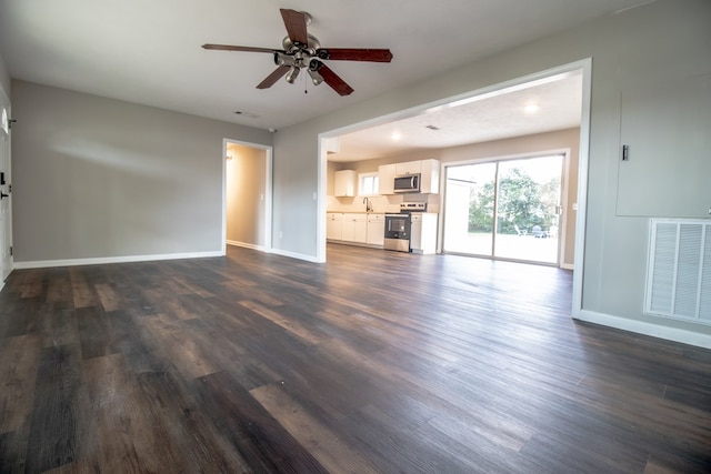 unfurnished living room featuring dark wood-type flooring, ceiling fan, and sink