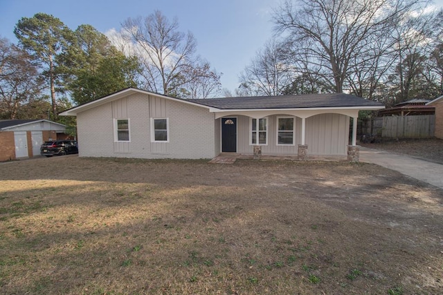 ranch-style home with a storage shed, a front yard, and a porch