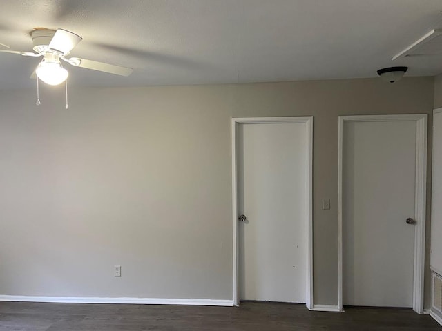 unfurnished bedroom with ceiling fan and dark hardwood / wood-style flooring