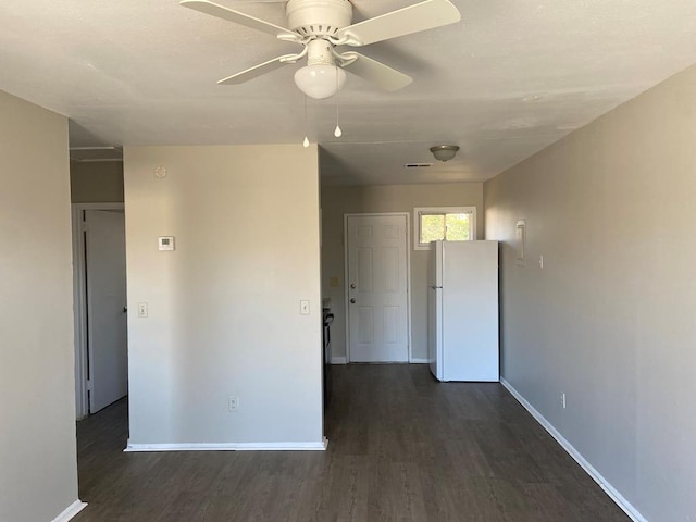 empty room with dark hardwood / wood-style flooring and ceiling fan