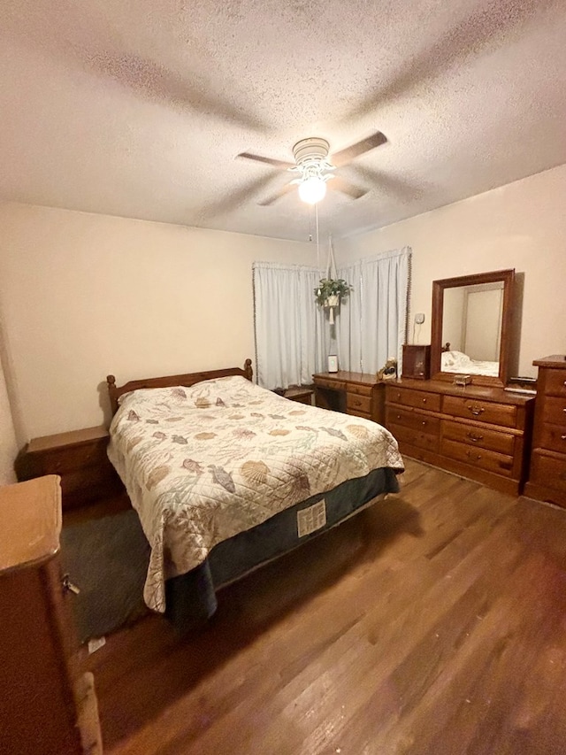 bedroom with a textured ceiling, ceiling fan, and wood finished floors