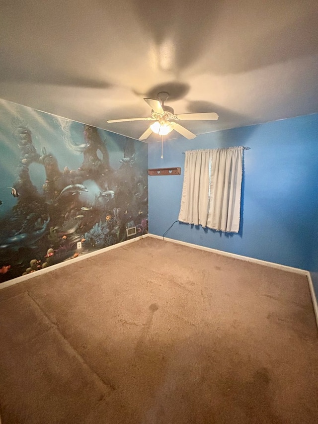 spare room featuring ceiling fan, carpet floors, and baseboards