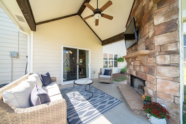 view of patio / terrace featuring ceiling fan and an outdoor stone fireplace