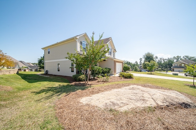 view of side of property featuring a garage and a yard