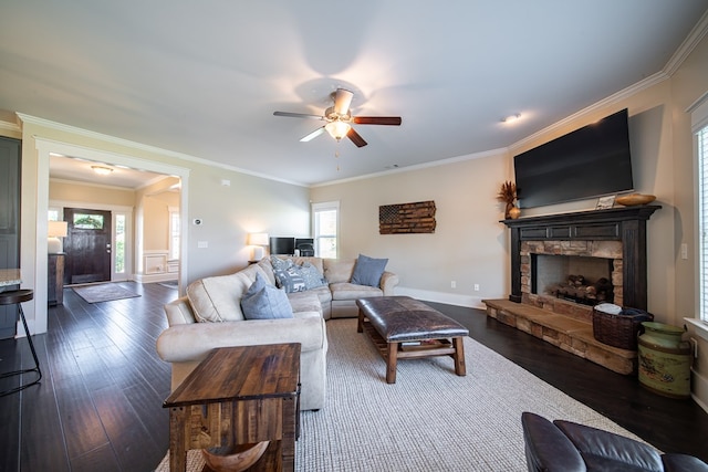 living room with a healthy amount of sunlight, dark hardwood / wood-style flooring, and crown molding