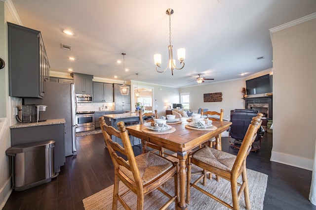 dining space with ceiling fan with notable chandelier, dark hardwood / wood-style flooring, and crown molding