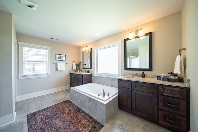 bathroom with vanity and tiled bath