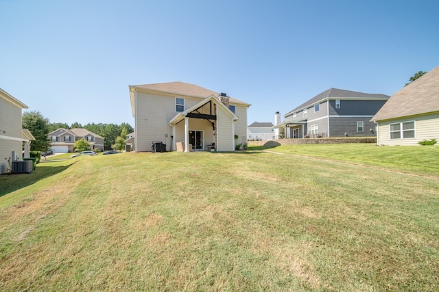 back of property featuring a yard and central AC