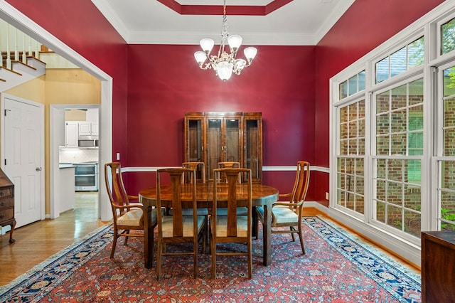 5043 Spyglass Ct, Columbus, GA 31909 - dining area featuring wood finished floors, a chandelier, beverage cooler, crown molding, and baseboards