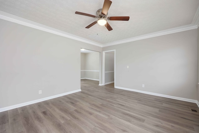 unfurnished room with crown molding, a textured ceiling, baseboards, and wood finished floors