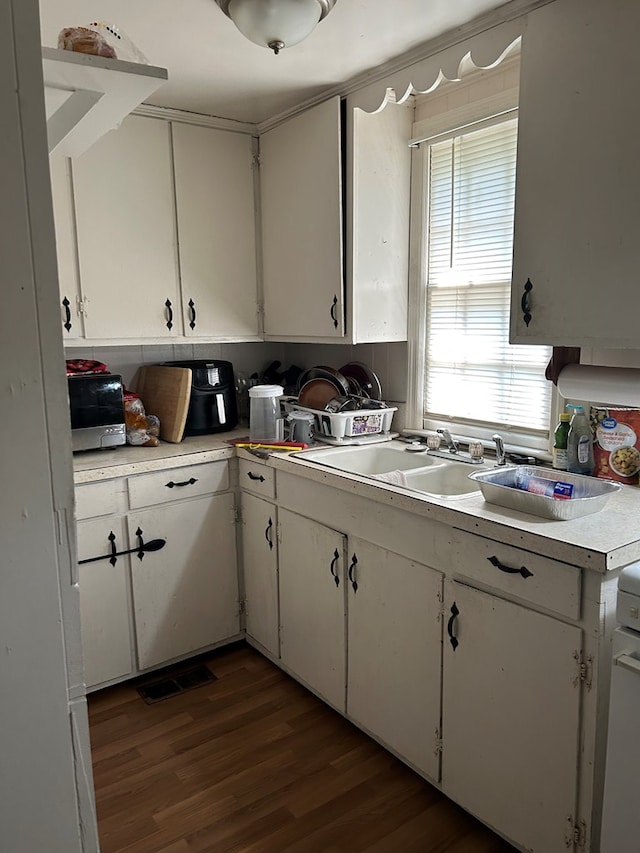 2821 Barbara Rd, Columbus, GA 31907 - kitchen featuring light countertops, white cabinetry, dark wood-style flooring, and a sink