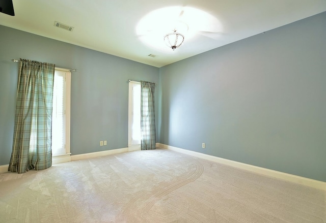 unfurnished room featuring carpet floors, visible vents, and baseboards