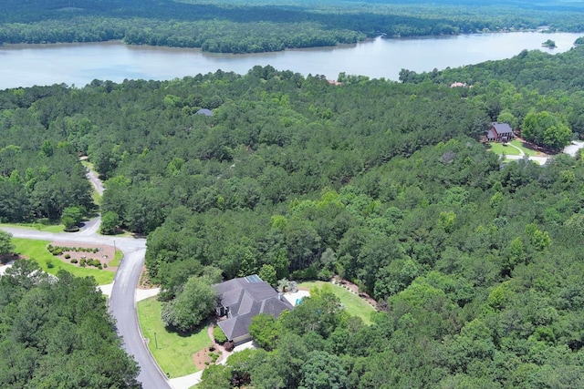 bird's eye view with a water view and a wooded view