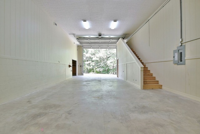 garage featuring concrete block wall and electric panel