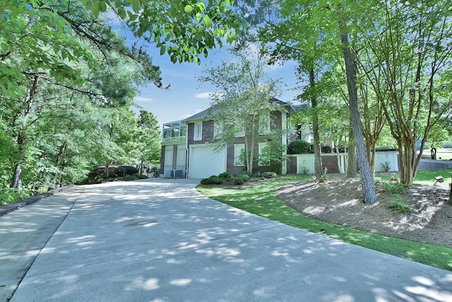 view of front facade featuring an attached garage, fence, and concrete driveway