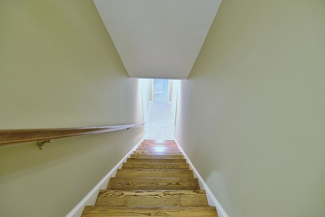 stairway featuring wood finished floors and baseboards