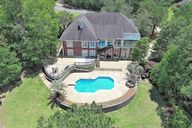 outdoor pool with stairs, a yard, a patio area, and a fenced backyard