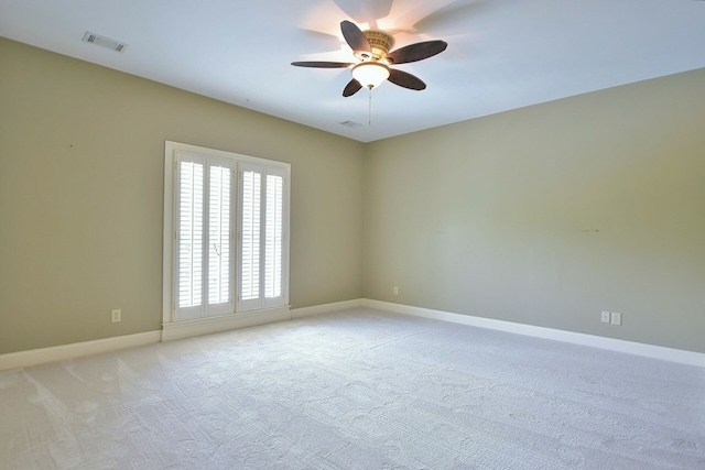 unfurnished room with light carpet, baseboards, visible vents, and ceiling fan