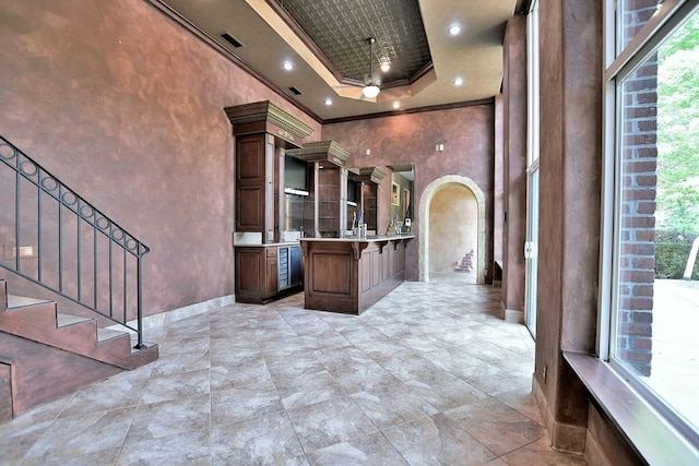 bathroom featuring a towering ceiling, visible vents, baseboards, ornamental molding, and a tray ceiling