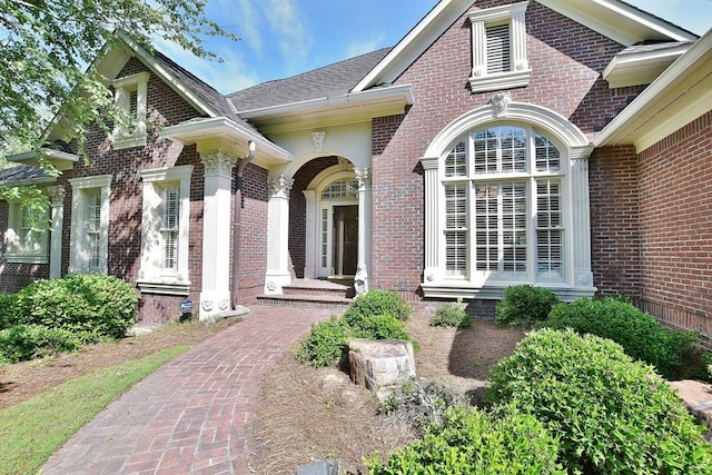 doorway to property featuring brick siding