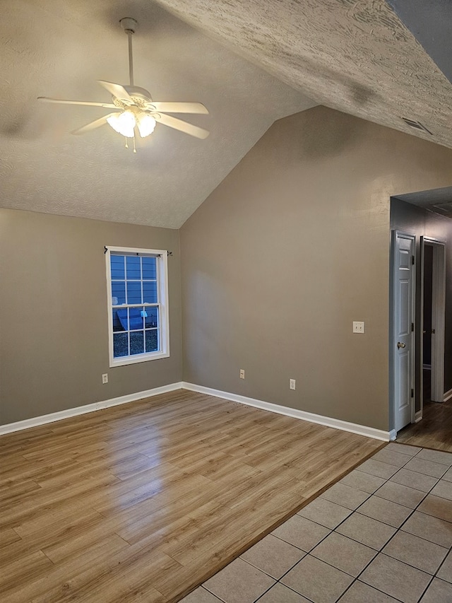 bonus room featuring a textured ceiling, light wood-type flooring, vaulted ceiling, and ceiling fan