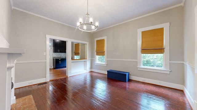 unfurnished dining area featuring wood-type flooring, a chandelier, crown molding, and baseboards