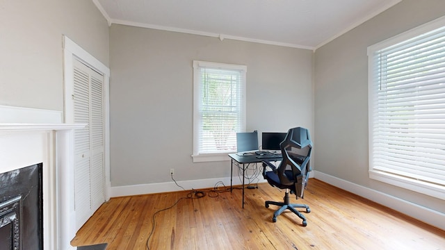 office space featuring crown molding, hardwood / wood-style floors, and baseboards