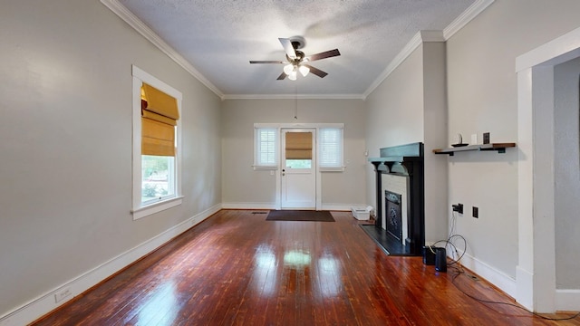 entryway featuring a fireplace with raised hearth, hardwood / wood-style flooring, a ceiling fan, baseboards, and crown molding