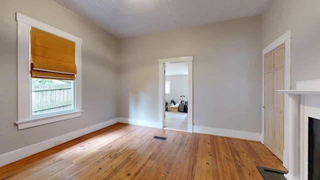 unfurnished living room featuring hardwood / wood-style flooring, baseboards, and a fireplace
