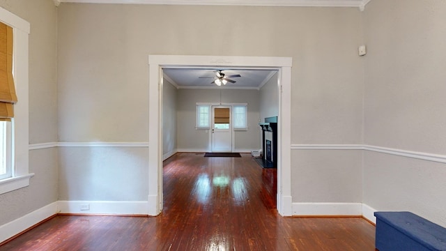 corridor with crown molding, wood finished floors, and baseboards