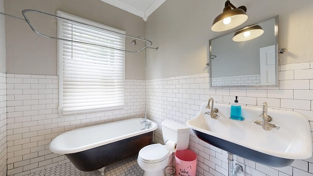 full bathroom with tile walls, crown molding, a freestanding bath, plenty of natural light, and toilet