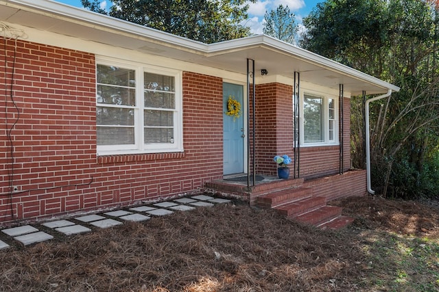 view of exterior entry with brick siding