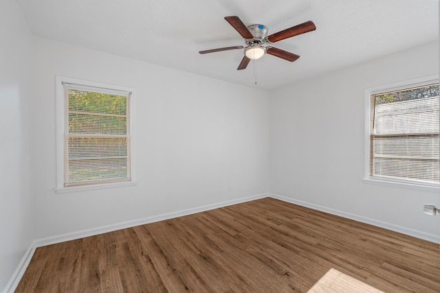 unfurnished room with a ceiling fan, baseboards, and wood finished floors