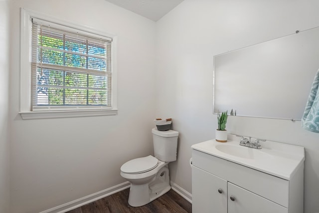 bathroom with wood finished floors, vanity, toilet, and baseboards