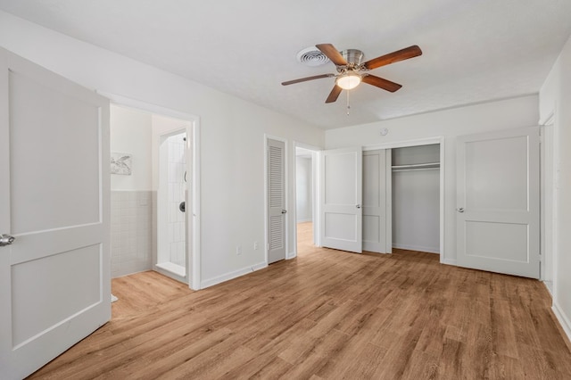 unfurnished bedroom featuring connected bathroom, visible vents, a ceiling fan, light wood-style floors, and a closet