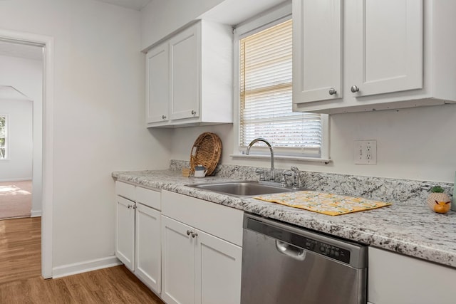 kitchen featuring light wood-style floors, white cabinets, dishwasher, and a sink