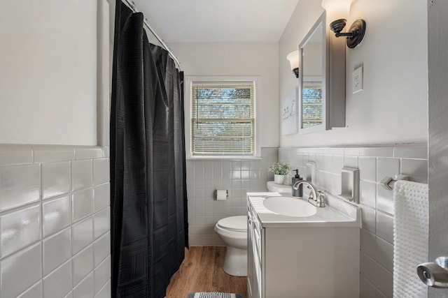 full bathroom featuring tile walls, vanity, toilet, and wood finished floors