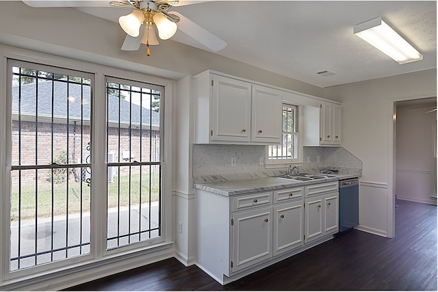 kitchen with dishwasher, sink, decorative backsplash, ceiling fan, and white cabinetry