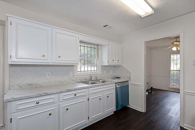 kitchen featuring stainless steel dishwasher, white cabinetry, sink, and tasteful backsplash