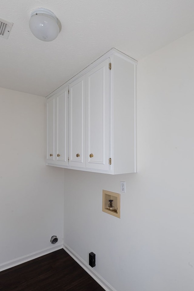 washroom featuring dark hardwood / wood-style flooring, hookup for a washing machine, and cabinets